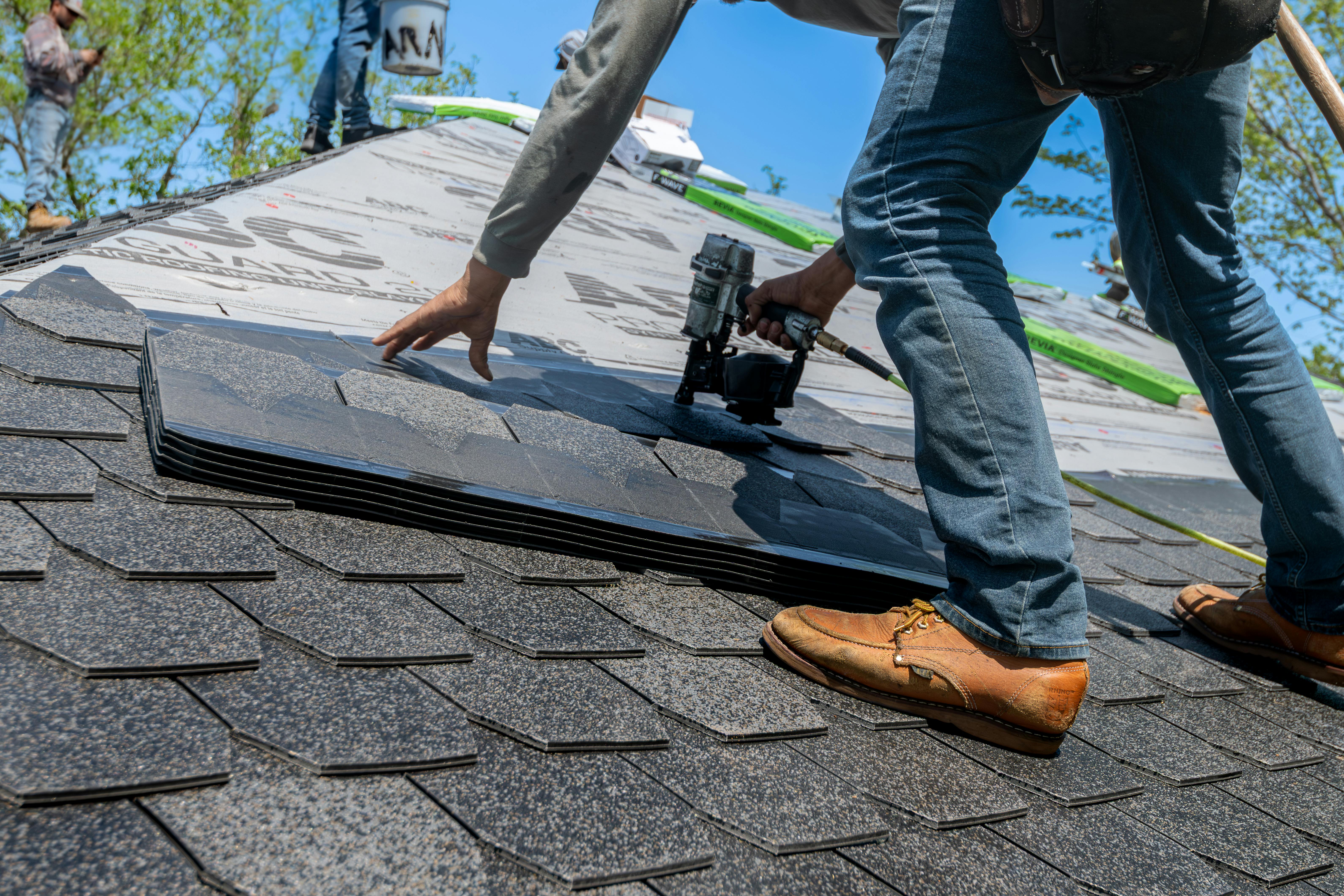 Roofing professional sealing shingles on a roof